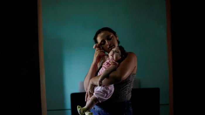 Raquel, 25, com sua filha Heloisa, no município de Areia, no estado da Paraíba, no Brasil. Raquel deu à luz filhas gêmeas com síndrome de Zika em abril de 2016. 