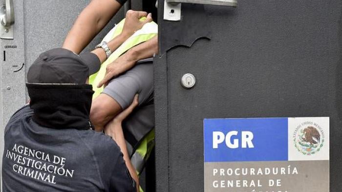 Attorney's General office's special agents embark into an armoured car some of the 27 municipal policemen involved in an attack against students in Iguala last month and now presented to the press in Mexico City on October 17, 2014. 