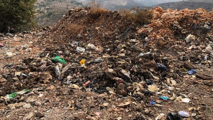 Signs of burning at the al-Qantara dump, including soot from recent burns and ash deposits. 