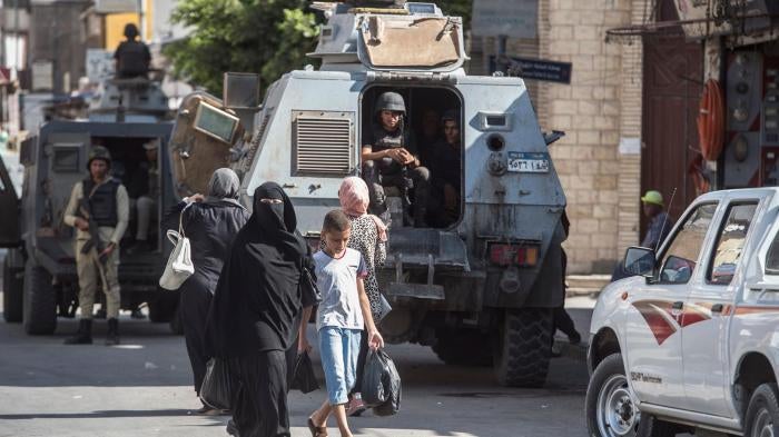A picture taken on July 26, 2018 shows Egyptian policemen stand guarding a street in the North Sinai provincial capital of El-Arish. With fruit and vegetables aplenty in the markets, public transport back on the roads and universities reopened, life is re