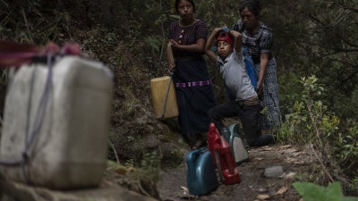 A woman and her children collect water 