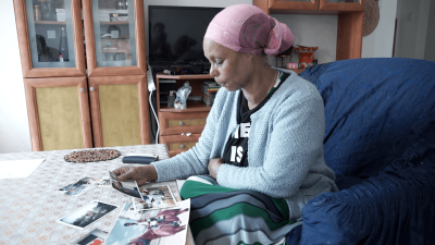 Mother looking at her missing son's photos.