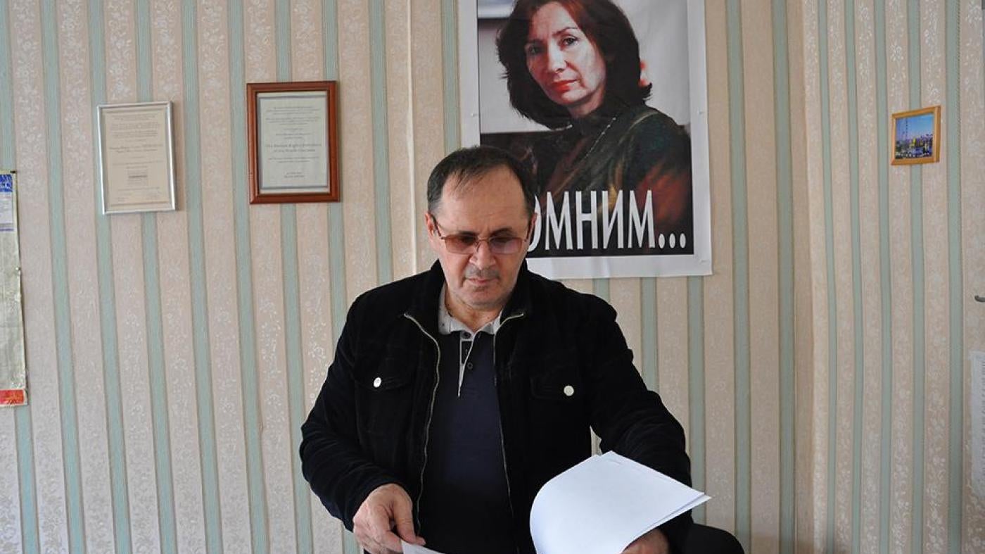 Oyub Titiev stands in front of a portrait of his murdered colleague, Natalia Estemirova, in Memorial's Grozny office, Grozny, Chechnya, Russia. 