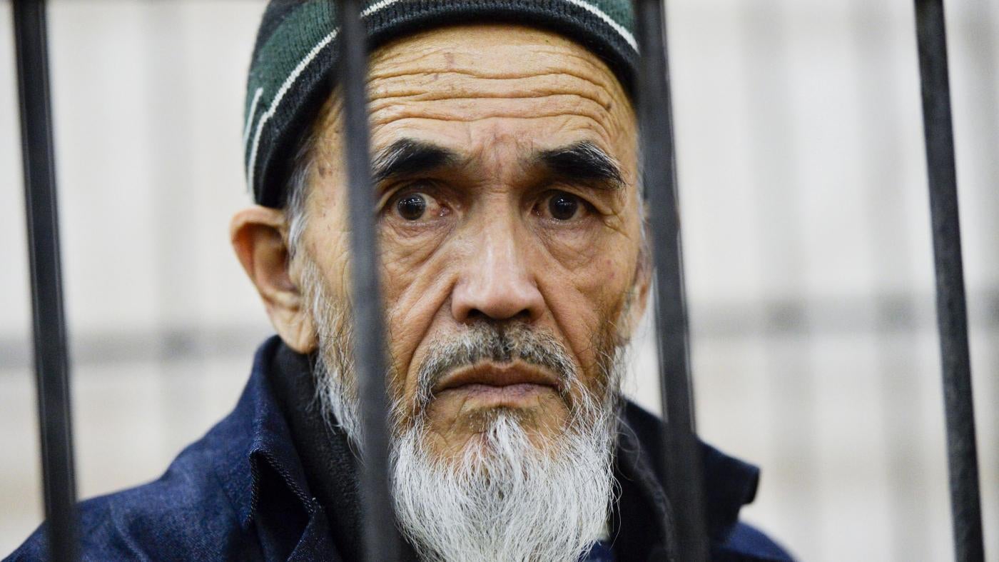 Ethnic Uzbek journalist Azimzhan Askarov, who was arbitrarily arrested, tortured, convicted after an unfair trial and jailed for life looks through metal bars during hearings at the Bishkek regional court, Kyrgyzstan.
