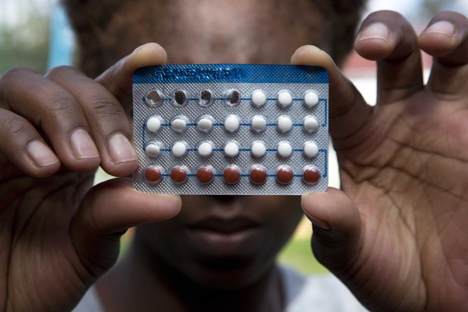 A woman holds a packet of contraceptive pills, in Harare, Thursday, April 9, 2020.