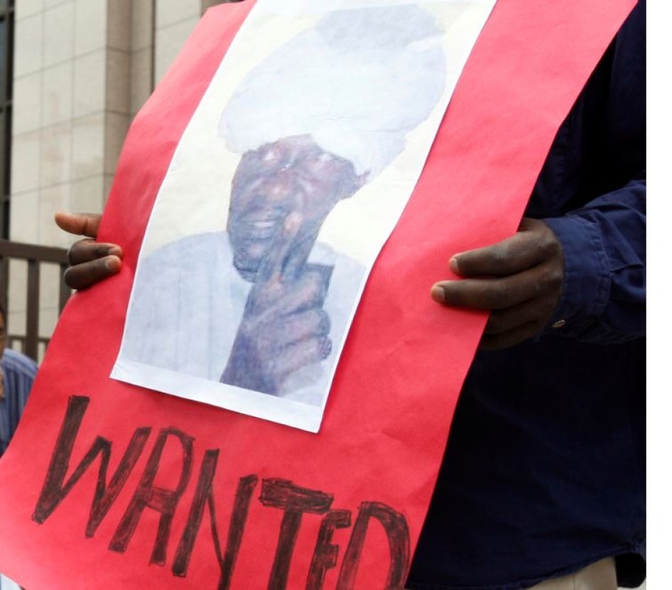  متظاهر يحمل لافتة عليها صورة علي كوشيب، أحد قادة ميليشيا "الجنجويد" السودانية، مع عبارة "مطلوب" بالإنغليزية، وآخر يحمل لافتة عليها صورة الرئيس آنذاك عمر البشير، مع عبارة "العدالة لدارفور" بالإنغليزية، أمام مقر "مجلس الاتحاد الأوروبي" في بروكسيل في يوليو/تموز 2008. الاثنان تتهمهما "المحكمة الجنائية الدولية" بارتكاب جرائم حرب. 