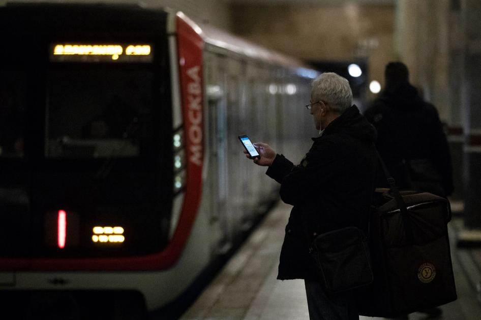 A man checks his smartphone while waiting to board a subway in Moscow, Russia, December 23, 2019. 