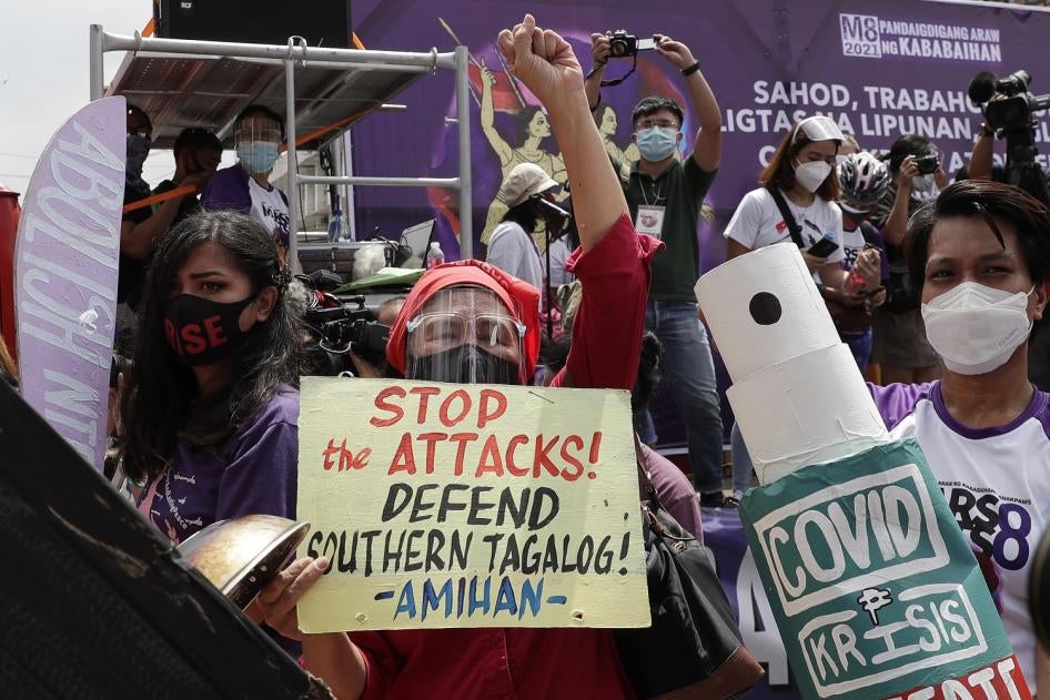 Protesters display slogans condemning the recent government attacks on activists during a rally near the Malacanang presidential palace on March 8, 2021 in Manila, Philippines.