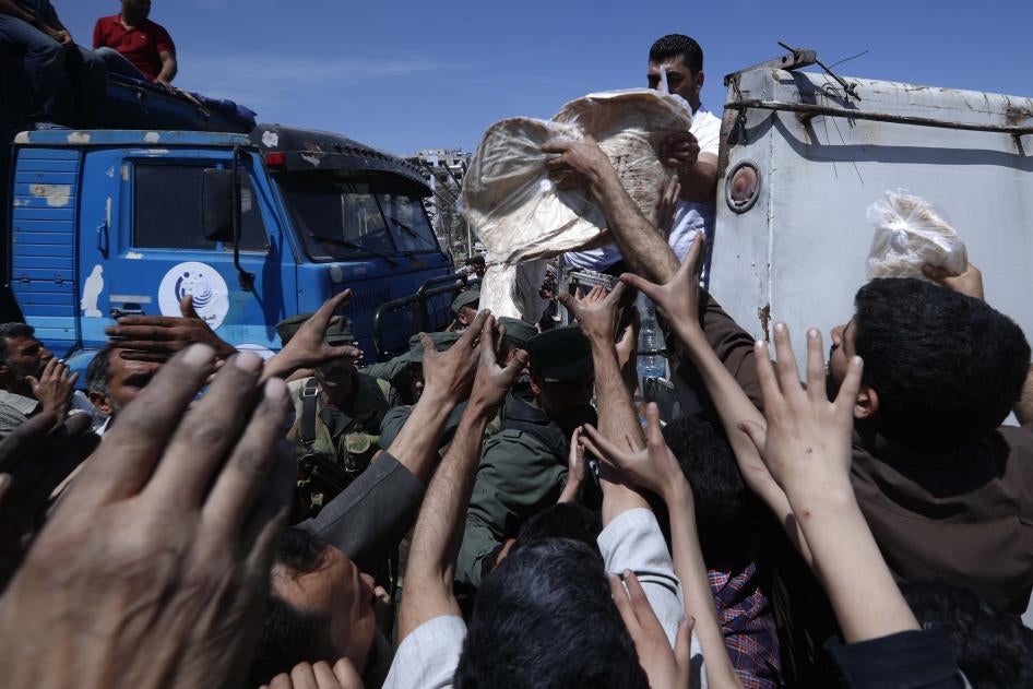 Syrian authorities distribute food to residents in the town of Douma, the site of a suspected chemical weapons attack, near Damascus, Syria, April 16, 2018.