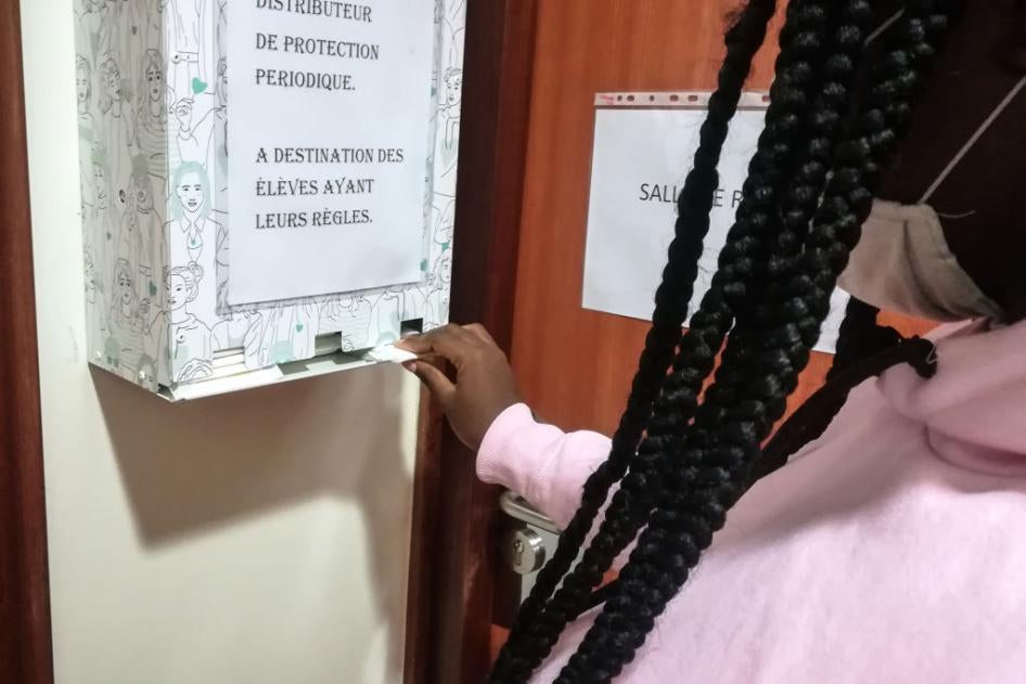 A pupil removes a free organic sanitary napkin from a dispenser at a high school