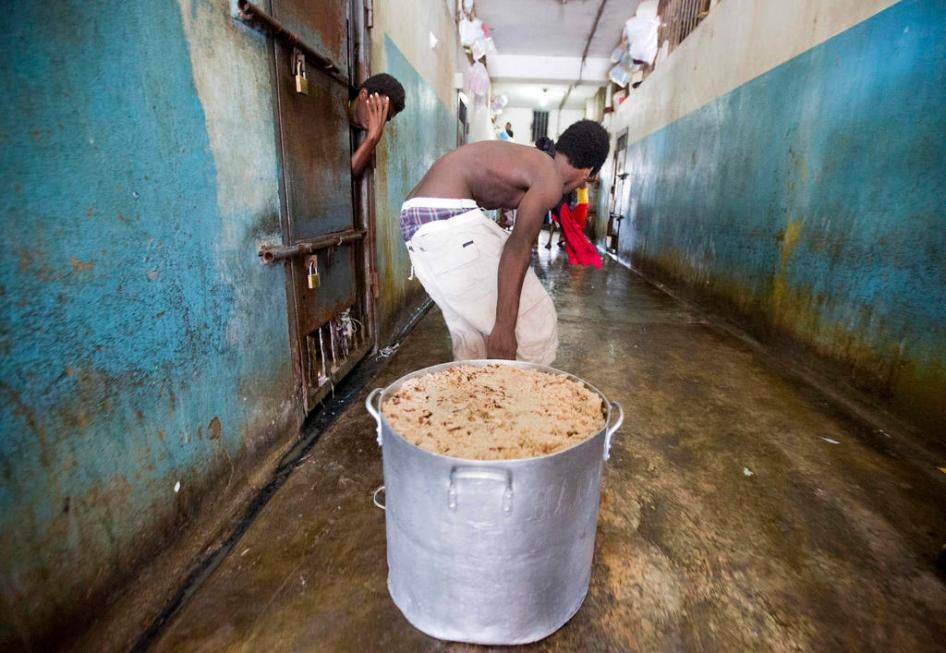 A detainee pulls a large stock pot filled with rice and beans during lunch inside the National Penitentiary in downtown Port-au-Prince, Haiti, on Febuary. 13, 2017. 