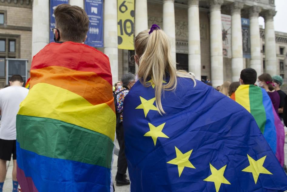 Demonstrators wrapped in LGBT and European Union flags are seen on August 30, 2020 in Warsaw, Poland. © 2020 Aleksander Kalka/NurPhoto via AP