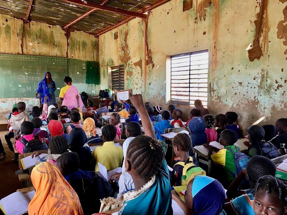 Une élève lève la main pour répondre à une question de son institutrice dans une salle de classe bondée d’une école primaire publique à Kaya, une ville de la région burkinabè du Centre-Nord qui accueille des dizaines de milliers de personnes déplacées. En janvier 2020, l’établissement comptait 748 élèves, dont 113 déplacés. « Chaque jour, des élèves déplacés viennent... Nous ne refusons pas d’inscriptions, mais s’il n’y a pas de places, ils ne peuvent pas commencer », a déploré le directeur de l’école. 