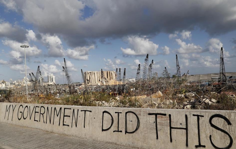 In this Aug. 9, 2020 file photo, political graffiti is visible in front of the scene of the August 4 explosion that hit the seaport of Beirut, Lebanon