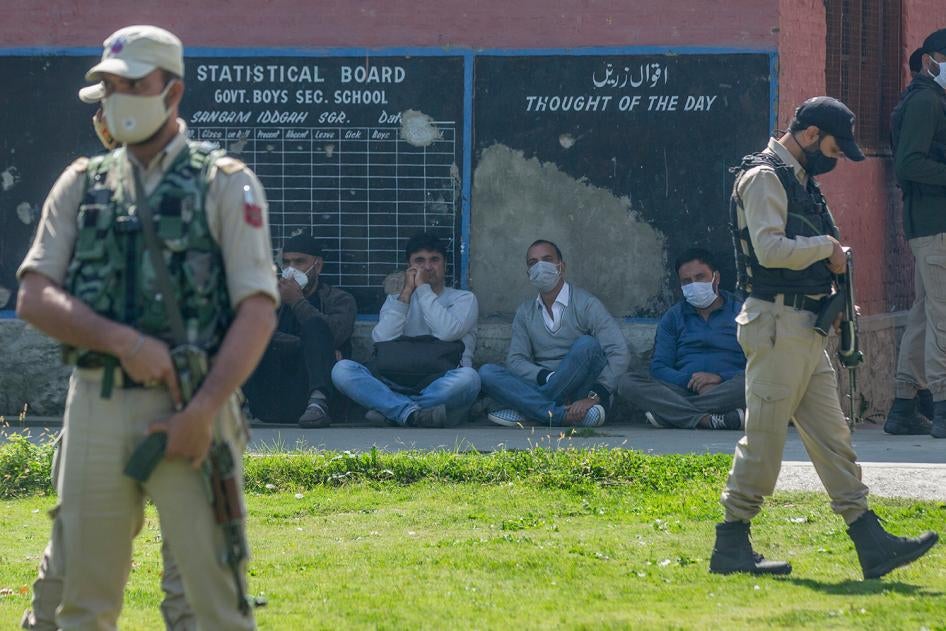 Indian paramilitary soldiers stand guard next to teachers at a government school where suspected militants fatally shot two teachers on the outskirts of Srinagar, India, October 7, 2021. 