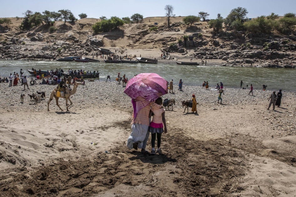 Refugees who fled the conflict in Ethiopia's Tigray region arrive on the banks of the Tekeze River on the Sudan-Ethiopia border, in Hamdayet, eastern Sudan, November 21, 2020.