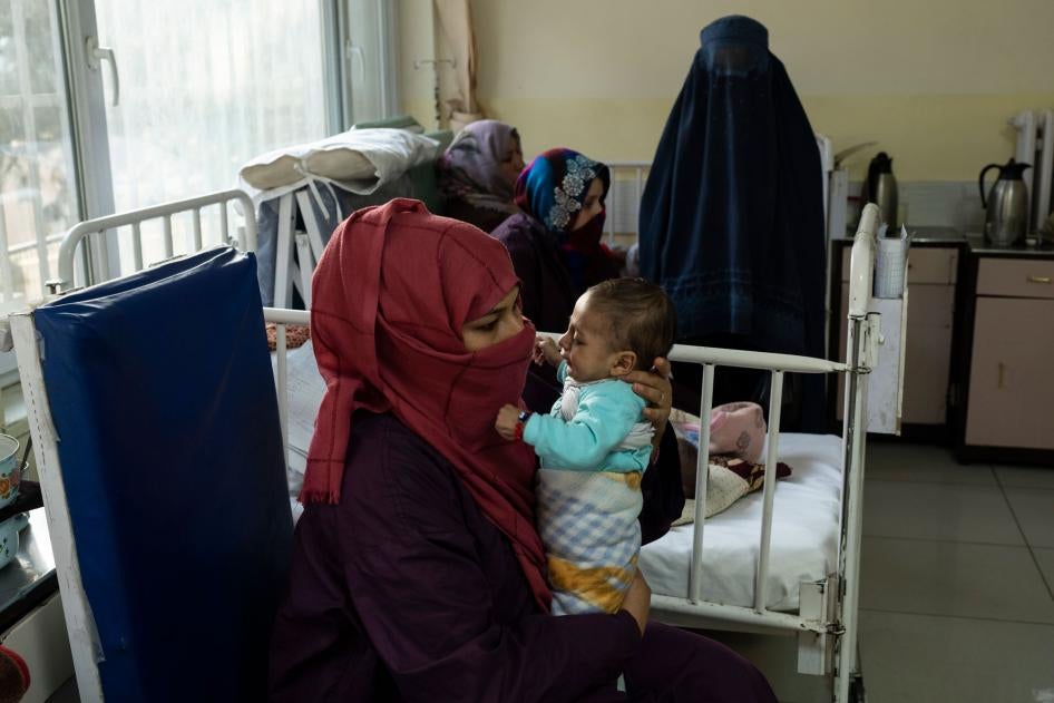 A woman holds her baby in a hospital room