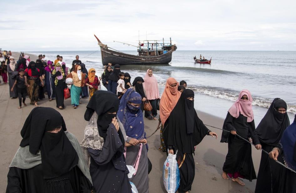 Ethnic Rohingya walk to a temporary shelter after they landed by boat in North Aceh, Indonesia.
