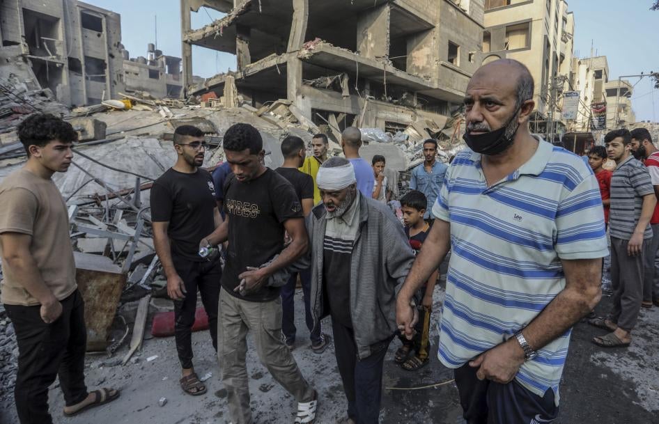 Palestinians help an injured older man following overnight Israeli air strikes on the Rafah refugee camp in Gaza, October 25, 2023.