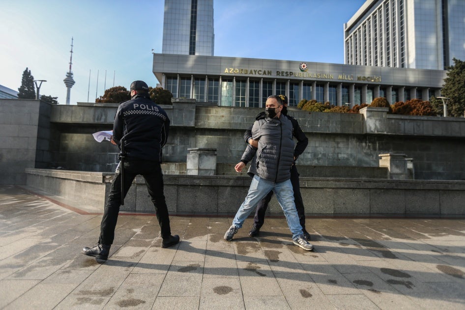 Police Police seize a poster that reads “Journalism is Not a Crime” during a protest by journalists in front of the Azerbaijan parliament building
