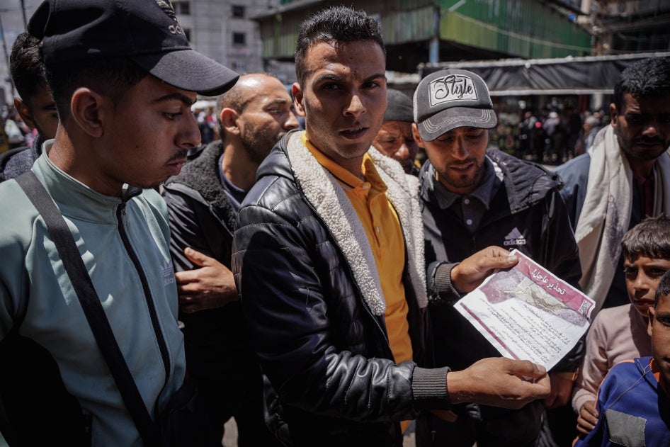 A group of Palestinians read a warning leaflet dropped by Israeli warplanes