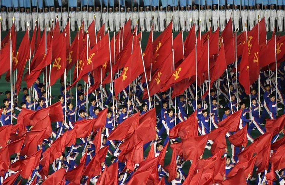 North Koreans hold Workers' Party flags during a mass performance in Pyongyang on July 26, 2013. 