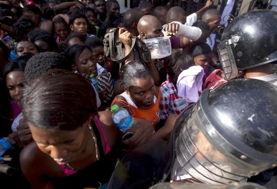 Haitians face police while waiting outside the Ministry of Interior and Police to register in Santo Domingo, June 16, 2015.