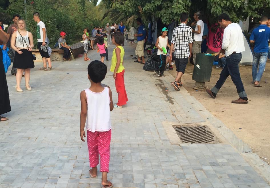 Афганские дети играют с волонтером в палаточном лагере в афинском парке Педион ту Ареос. В начале недели правительство обнародовало планы переселения людей из парка в лагерь, который оно собирается оборудовать.