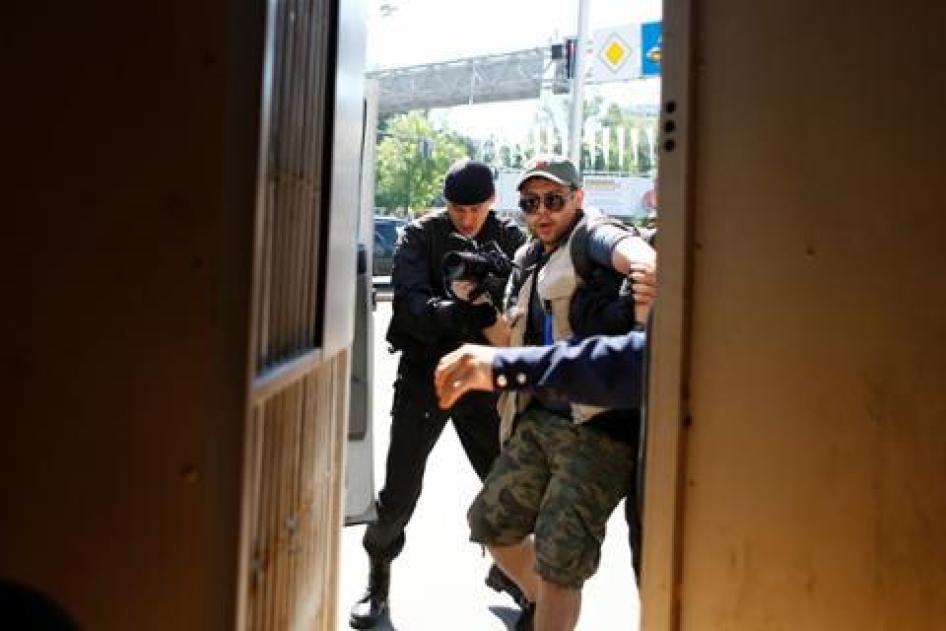 Riot police officers briefly detain a journalist during a protest against President Nursultan Nazarbayev's government and an unpopular land reform proposal, in Almaty, Kazakhstan on May 21, 2016.