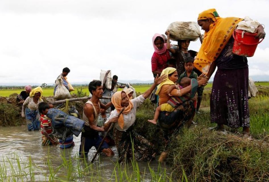 A group of Rohingya refugees cross a canal after travelling over the Bangladesh-Burma border in Teknaf, Bangladesh, September 1, 2017.