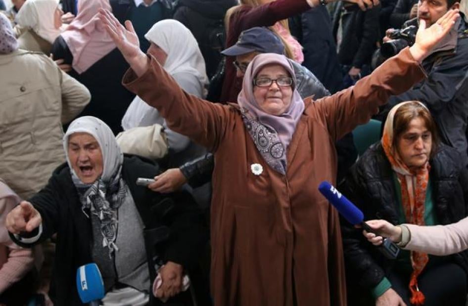 A woman reacts as she watches a television broadcast of the court proceedings of former Bosnian Serb general Ratko Mladic in the Memorial centre Potocari near Srebrenica.