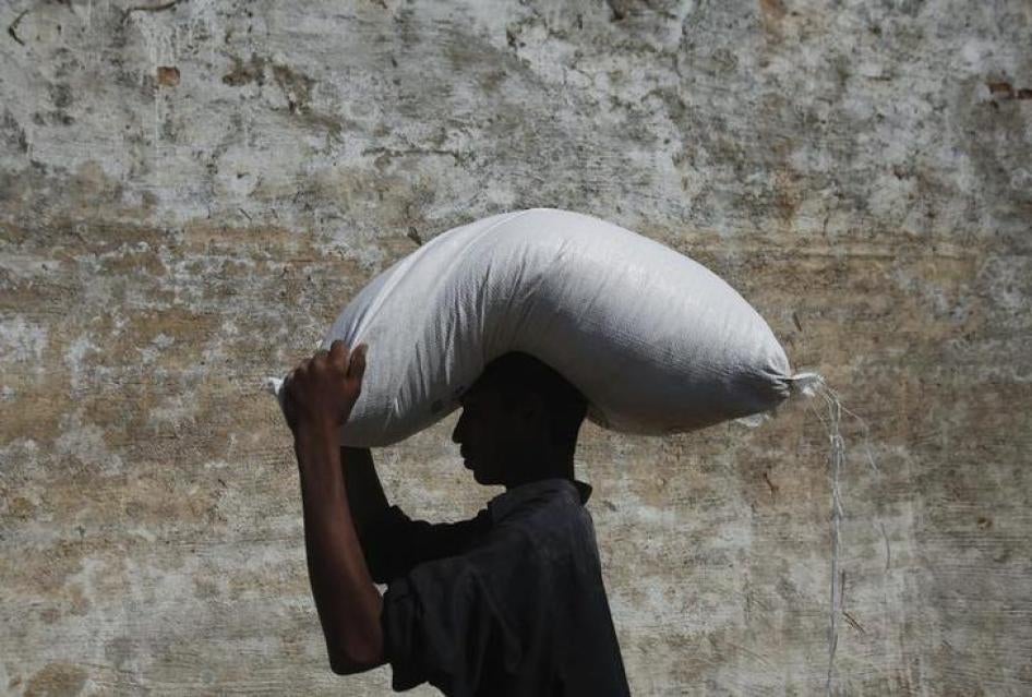 201712asia_pakistan_ngos2 A flood victim carries a sack of flour on his head from a distribution point while heading to his village of Murad Chandio, some 35 km (22 miles) from Dadu in Pakistan's Sindh province January 26, 2011. 