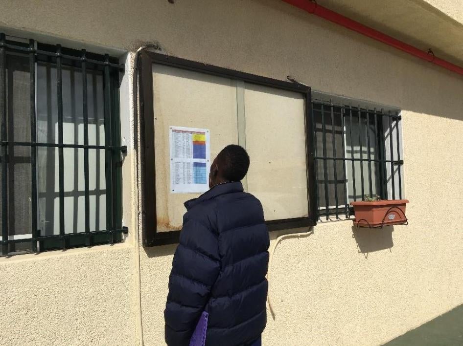 Migrant looking at list of people to be transferred from Ceuta to mainland Spain, March 2017