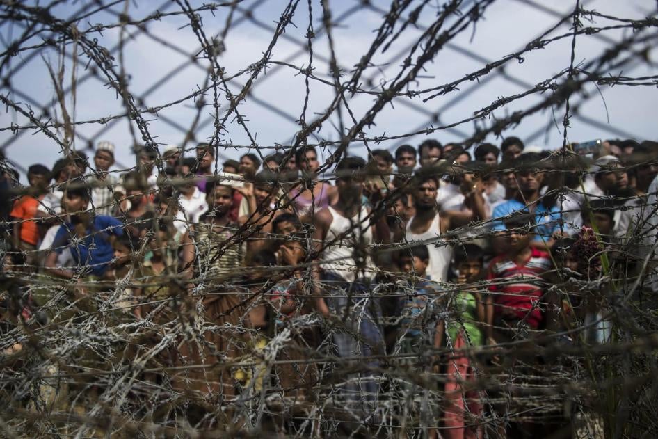 Rohingya refugees gather behind a barbed-wire fence in the “no-man’s land” border zone between Myanmar and Bangladesh, April 25, 2018.