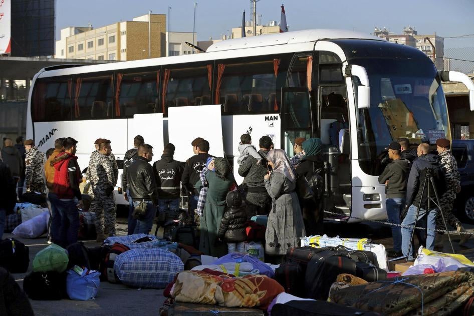 Members of the Lebanese General Security Directorate oversee Syrian refugees boarding a bus to take them home to Syria, in the northern Beirut suburb of Burj Hammoud, Lebanon, Thursday, Jan. 24, 2019. © 2019 AP Photo/Bilal Hussein