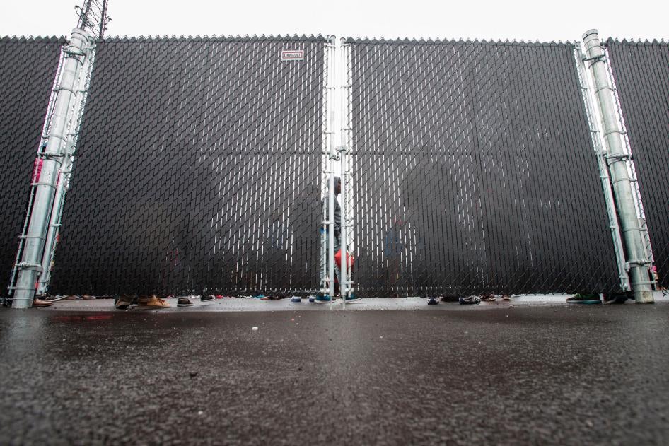 People wait in a temporary detention center in Blackpool, Quebec, August 5, 2017.