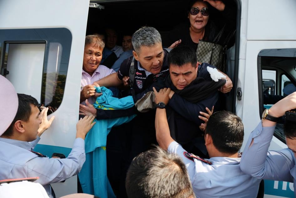 Kazakhstan's police officers push arrested protesters into a police bus during an opposition rally in Almaty, Kazakhstan, September 21, 2019. 