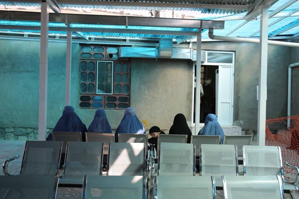 A group of seated women in an outdoor hospital waiting room
