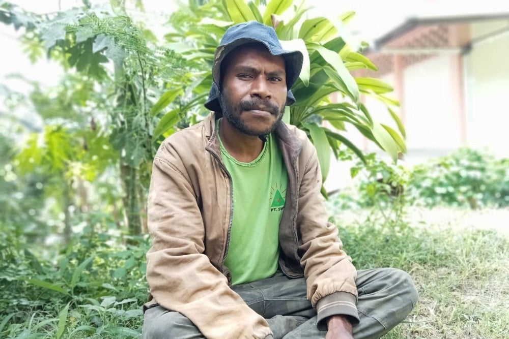 A man poses for a photo while seated