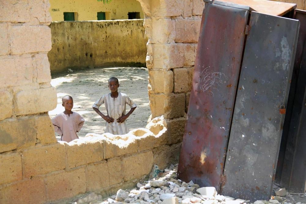 Children look through a destroyed classroom window at Yerwa Primary School, Maiduguri, Borno state, damaged by Boko Haram during attacks in 2010 and 2013. The school, established in 1915, was the first primary school in northeast Nigeria. © 2015 Bede Shep