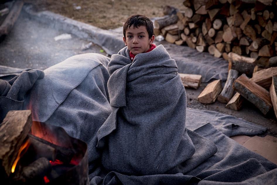 A Syrian boy wakes up after spending a freezing night sleeping outside at a petrol station near the Greek border with Macedonia. January 29, 2016.