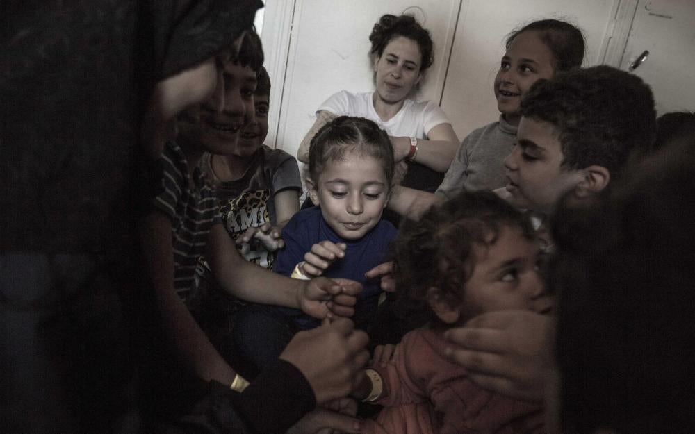 Hanan, a Syrian woman, sits in the women’s shelter on board the Aquarius while children from her family and other Syrian families play. October 13, 2017.