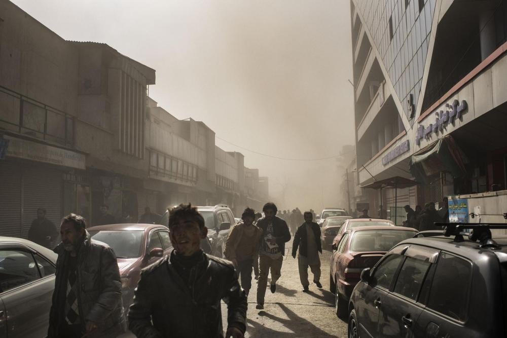 People flee after an ambulance rigged with explosives detonated in central Kabul, killing 103, January 27, 2018.