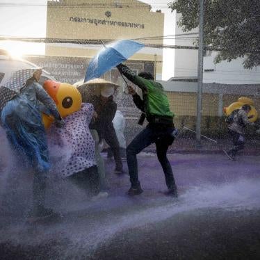 Democracy demonstrators take cover with inflatable ducks and umbrellas as police use water cannons during a protest rally near the parliament in Bangkok, November 17, 2020. © 2020 AP Photo/Wason Wanichakorn