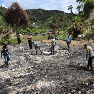 Villagers and police officers clean up debris at the site of suspected militant attack in Lembantongoa village in Sulawesi, Indonesia, November 30, 2020. 