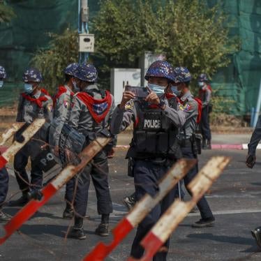 A police officer takes visuals of protesters close to the Indonesian Embassy in Yangon, Myanmar Wednesday, Feb. 24, 2021. 