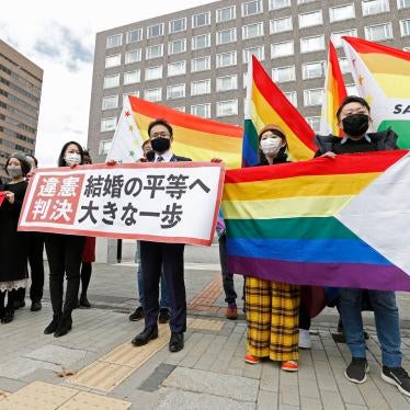 Lawyers and supporters hold rainbow flags and a banner outside Sapporo District Court in Sapporo, Japan, March 17, 2021. 