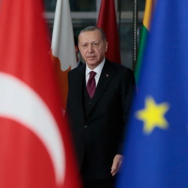 Turkish President Recep Tayyip Erdogan is seen walking near the Turkish and European Union flags.