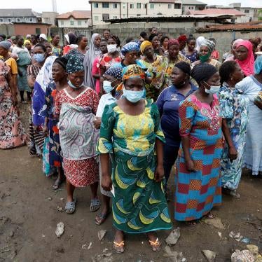A group of women wait for food relief distribution