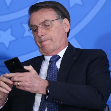 Brazil’s President Jair Bolsonaro uses his cellphone during at event at the presidential palace in Brasilia on June 13, 2019. 